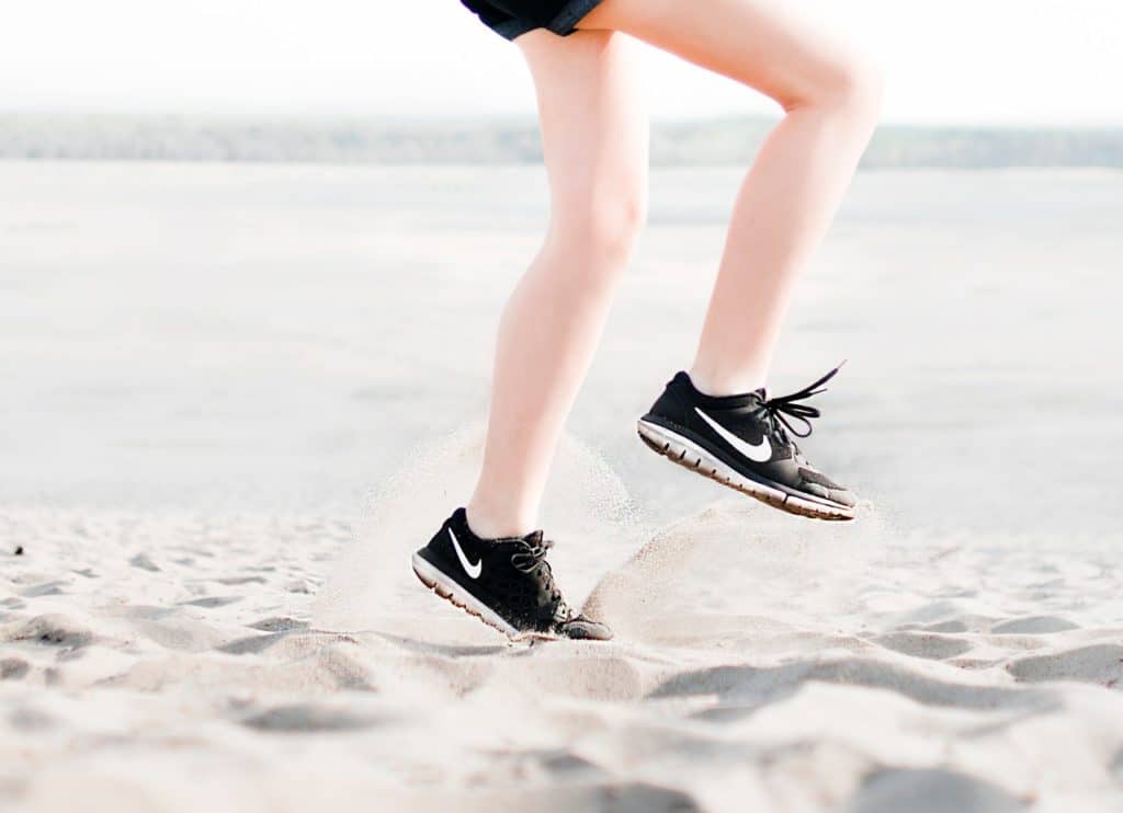 photo of woman wearing pair of black nike running shoes 1166868 1024x742