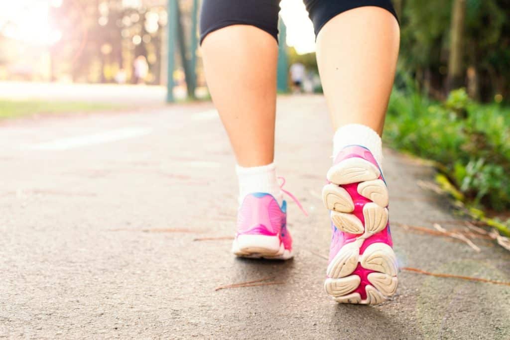 photo of woman wearing pink sports shoes walking 1556710 1024x683